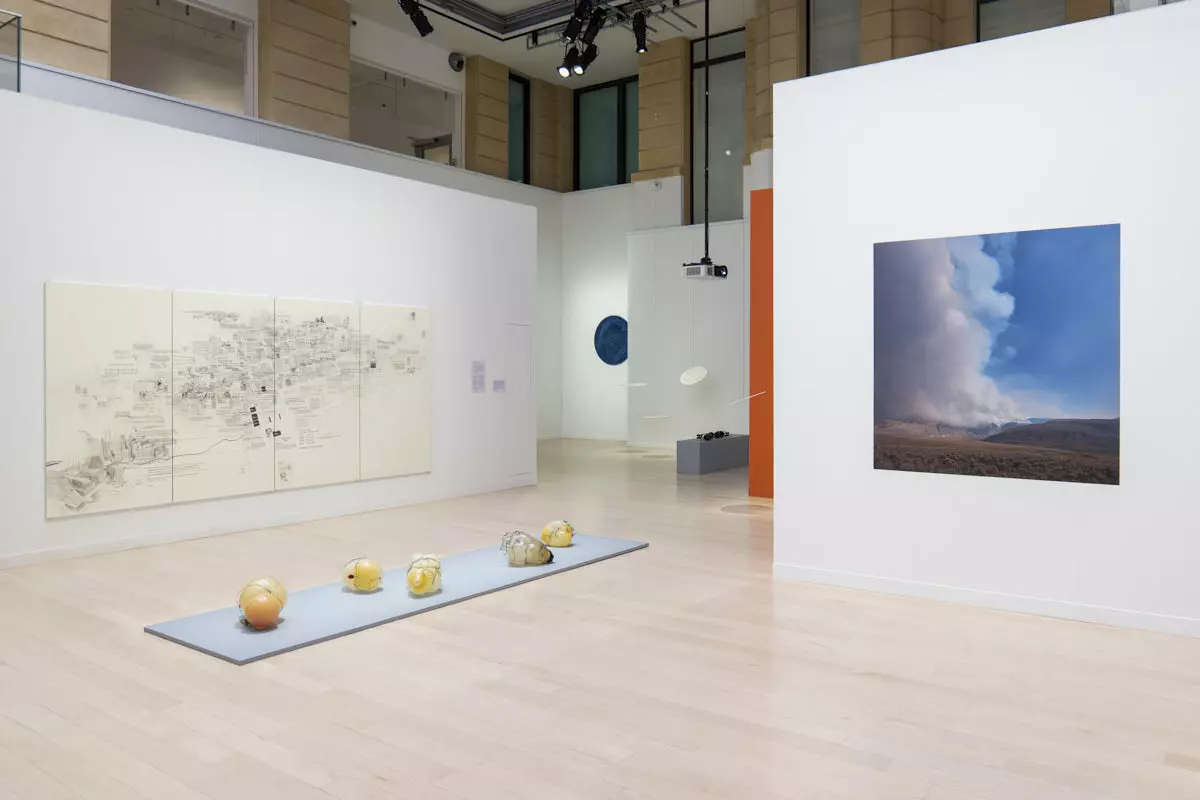 White Mila-wall walls with a drawing and a photograph at the Canadian Cultural Centre in Paris, with objects on a low platform in front